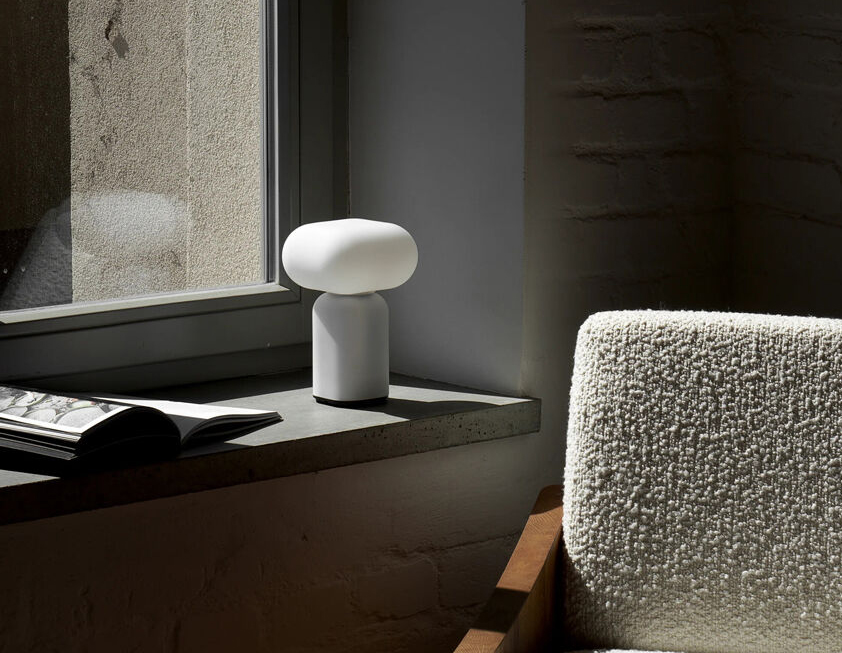 Velis Table Lamp - Lightweight Design, Compact and Wireless, Easy to Carry Anywhere 3 “Velis table lamp with rounded cloud‑like shade and cylindrical base on a concrete windowsill beside an open book